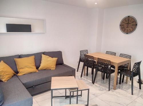 a living room with a couch and a table at Résidence le Serra A2 in Juan-les-Pins