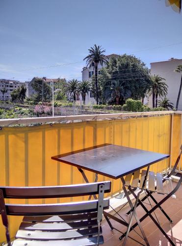 d'une table et de chaises sur un balcon avec un mur jaune. dans l'établissement Résidence le Serra A2, à Juan-les-Pins