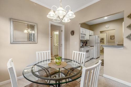 a dining room with a glass table and white chairs at Creekwood - 400 Cascade Ln Unit# 418 in Rehoboth Beach