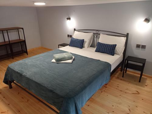 a bedroom with a large bed with blue and white pillows at Xristos apartment and maisonettes in Sykia Chalkidikis