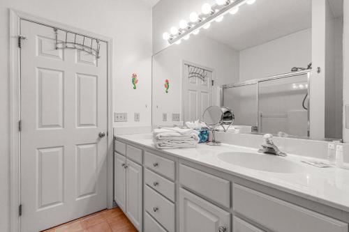 La salle de bains blanche est pourvue d'un lavabo et d'un miroir. dans l'établissement Creekwood - 400 Cascade Ln Unit# 418, à Rehoboth Beach