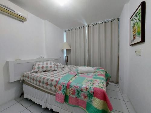 um quarto com uma cama com uma colcha em Apto. 1 dormitório no M. de Nassau - Ed. Manhattan Home Service 302 em Caruaru