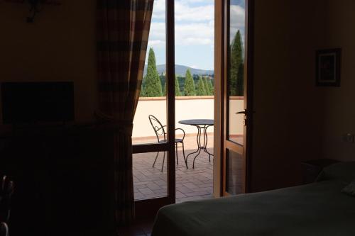 a bedroom with a door open to a patio with a table at Appartamenti Casalsole in Cerreto Guidi