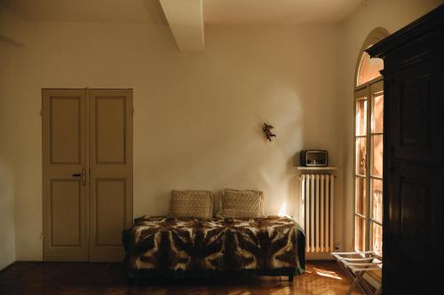 a living room with a bed and a window at Le dimore de Il borgo del balsamico in Albinea
