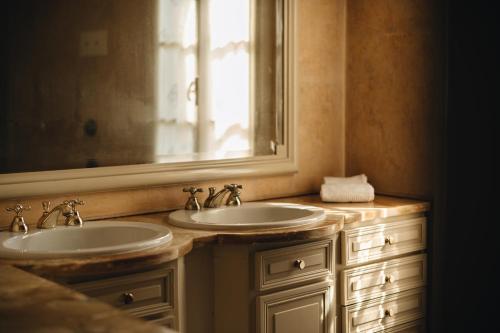 a bathroom with two sinks and a mirror at Le dimore de Il borgo del balsamico in Albinea