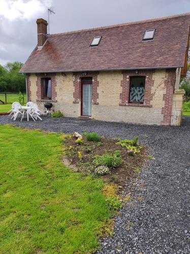 a brick house with two white chairs in front of it at LE GITE ADORE in Bissières