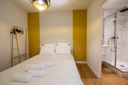 1 Schlafzimmer mit einem großen weißen Bett und 2 Handtüchern in der Unterkunft WelcomeAgen*Clim*Fibre*Salvador Dali in Agen