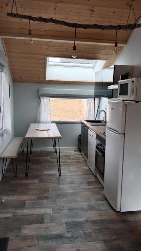 a kitchen with a table and a white refrigerator at Gîte des Roches in La Chaux-du-Dombief