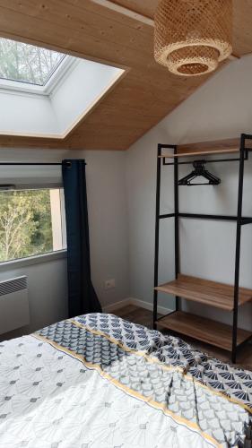 a bedroom with a bed and a skylight at Gîte des Roches in La Chaux-du-Dombief