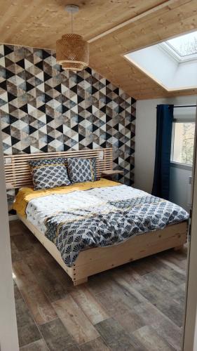 a bedroom with a bed with a checkered wall at Gîte des Roches in La Chaux-du-Dombief