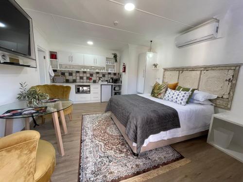 a bedroom with a bed and a table and a kitchen at INBLOEM in Bloemfontein
