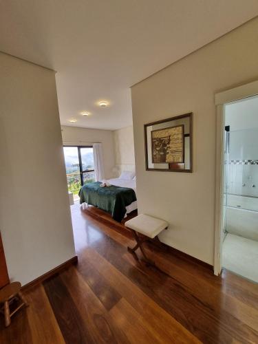 a bedroom with a bed and a room with a window at Casa Primavera by The Lodges in Campos do Jordão