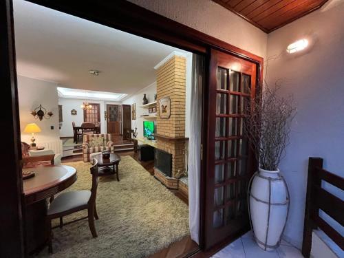 カンポス・ド・ジョルドンにあるApartamento Ville Dijon Capivari by Capivari Lodgeのリビングルーム(テーブル、花瓶付)