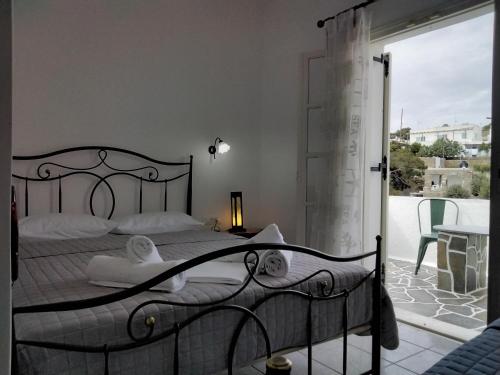 a bedroom with a bed and a balcony at Nikolas ios Village in Ios Chora