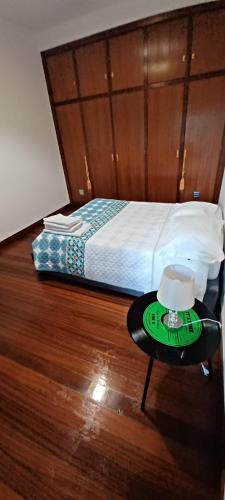 a bedroom with a bed and a table with a clock on it at Quinta do Carvalho - Nature Guest Houses in Guimarães