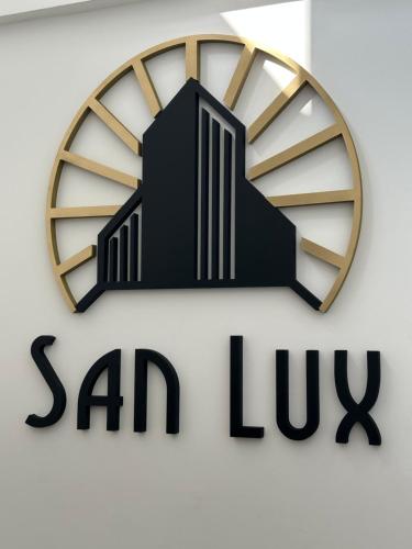 a clock on a wall with a saanlux sign at San Lux Dunavska in Novi Sad