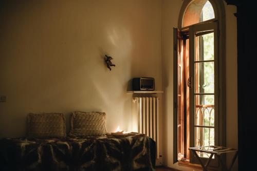 a living room with a couch and a window at Le dimore de Il borgo del balsamico in Albinea