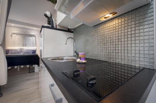 uma cozinha com um balcão preto e um lavatório em Apartments Casa Ivona em Rovinj