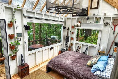 a bedroom in a tiny house with a bed and windows at Stabbin Cabin #2 on Grant Island - Worlds Raddest Island in Glenfield