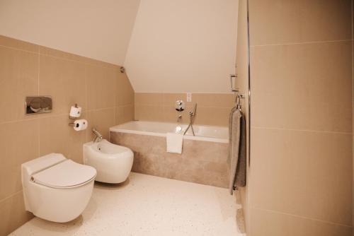 a bathroom with a toilet and a bath tub at Hotel & Spa Savarin - Rijswijk, The Hague in Rijswijk