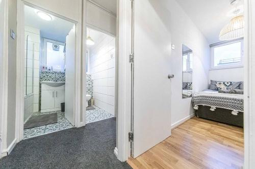 a room with a bathroom with a bed and a mirror at Buckland court in London
