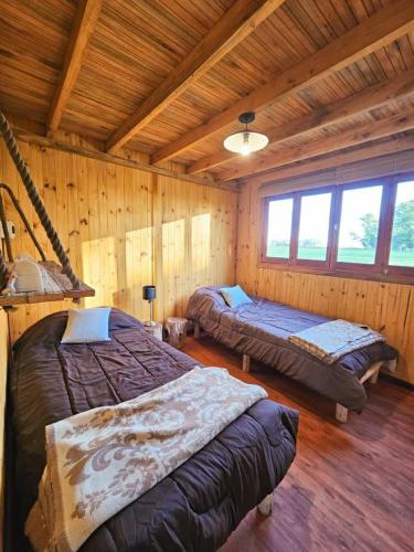 1 dormitorio con 2 camas en una cabaña de madera en TERRA en San Andrés de Giles
