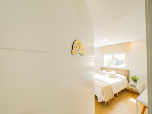Habitación blanca con cama y ventana en Cubo's Hostal William's Sunny 2 with Breakfast, en Torre de Benagalbón