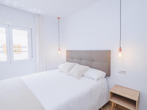 a white bedroom with a large bed and a window at Cubo's Hostal William's Sunny 4 with Breakfast in Torre de Benagalbón
