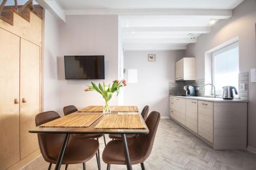 una sala da pranzo con tavolo e sedie in cucina di Domki Apartamentowe - Na Makowej a Jastrzębia Góra