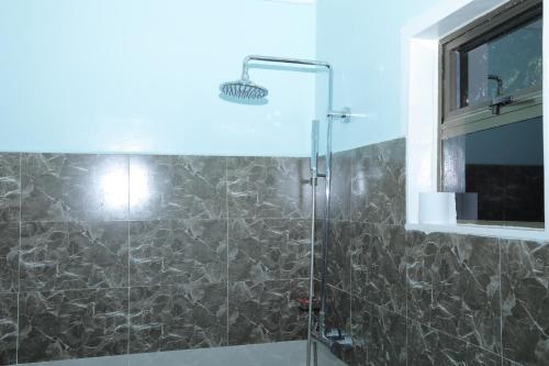 a bathroom with a shower with a glass door at Riverside Villas Nanyuki in Nanyuki