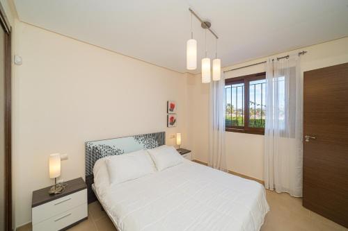 Un dormitorio con una cama blanca y una ventana. en Orquidea, en San Juan de los Terreros