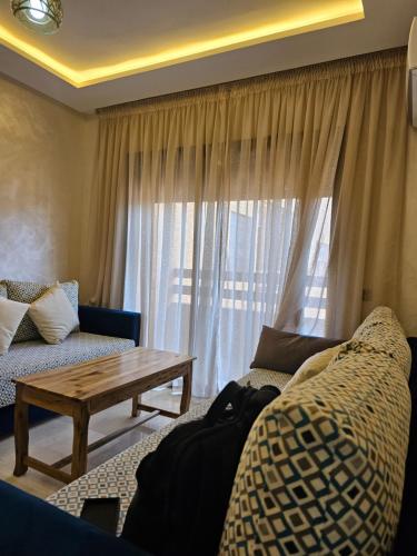 a living room with a couch and a table and a window at Appartement de rêve 2 in Marrakech