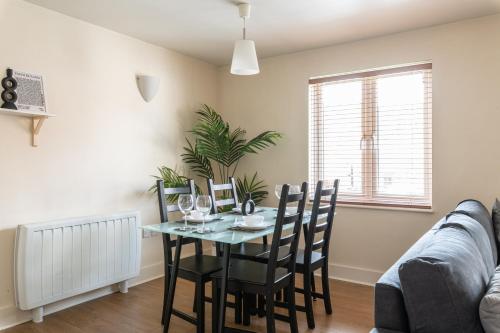 uma sala de jantar com uma mesa e cadeiras e um sofá em Spacious, Modern, Fully Furnished Apartment - 2 FREE PARKING Spaces - 8 min LGW Airport em Crawley