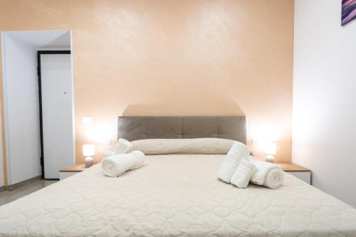 a bedroom with a large white bed with two white pillows at Napul'è B&B in Boscotrecase