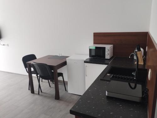 a small kitchen with a table and a microwave at Apartmány Adam in Liptovská Teplá