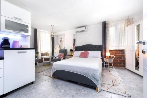 um quarto branco com uma cama e uma cozinha em Apartments Casa Ivona em Rovinj