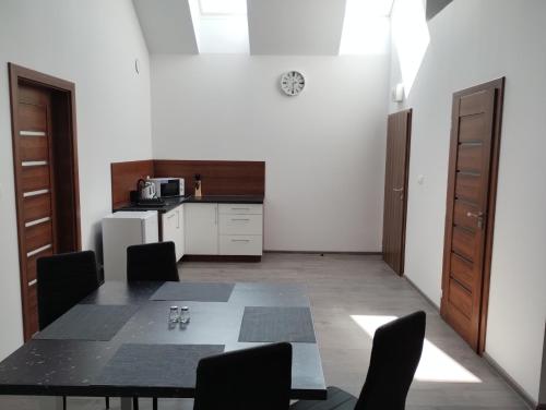 a dining room with a table and a kitchen at Apartmány Adam in Liptovská Teplá