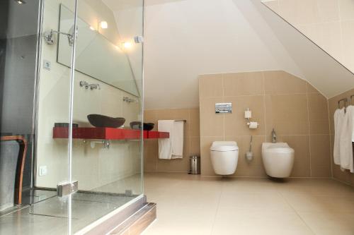 a bathroom with two toilets and a glass shower at Hotel & Spa Savarin - Rijswijk, The Hague in Rijswijk