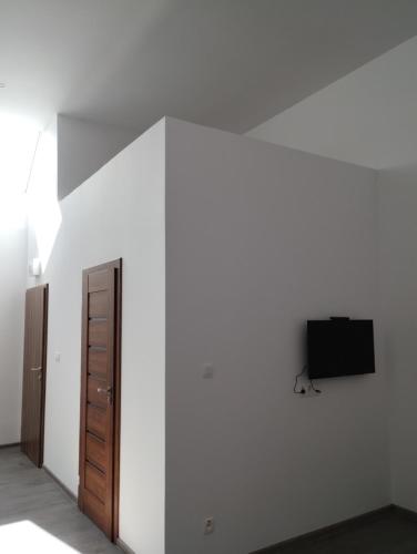 a room with a white wall and a tv on a wall at Apartmány Adam in Liptovská Teplá
