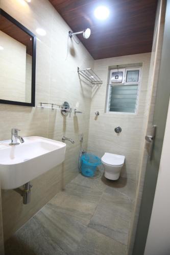a bathroom with a sink and a toilet at Hotel Royal Blooms in Bangalore