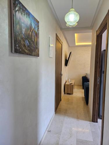 a hallway with a painting on the wall and a couch at Appartement de rêve 2 in Marrakech