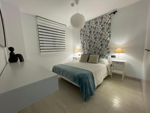 加的斯的住宿－LHOME CÁDIZ，一间卧室配有一张床、一张桌子和一个窗户。
