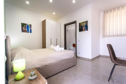 1 dormitorio con 1 cama y 1 mesa con lámpara en Napul'è B&B, en Boscotrecase