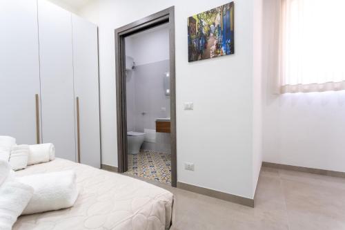 a bedroom with a bed and a bathroom with a toilet at Napul'è B&B in Boscotrecase