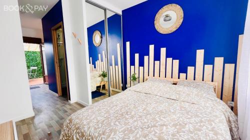 ein Schlafzimmer mit einer blauen Wand und einem Bett in der Unterkunft Les studios de la Villa Jules Verne in Amiens