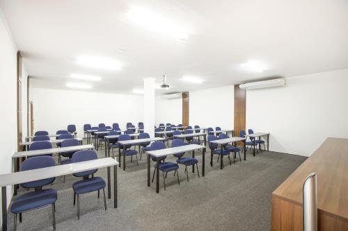 an empty classroom with desks and chairs in a room at Sumaré Park Hotel in Sumaré