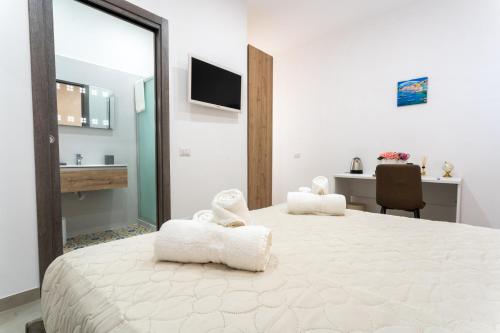 a bedroom with a large bed with two white towels at Napul'è B&B in Boscotrecase