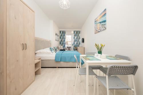 a bedroom with a bed and a table and chairs at Apartament ANTEK Dziwnówek nad morzem in Dziwnówek