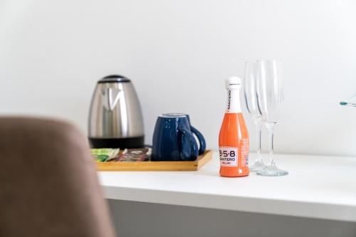 a bottle of beer sitting on a counter next to glasses at Napul'è B&B in Boscotrecase