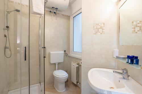 W łazience znajduje się umywalka, toaleta i prysznic. w obiekcie Re di Roma - Charme Apartment w Rzymie